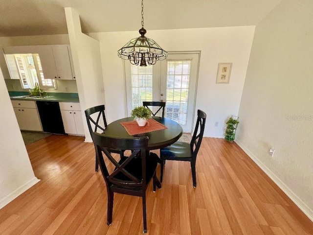 dining area featuring a chandelier, baseboards, plenty of natural light, and light wood-type flooring