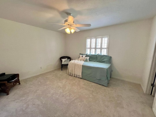 bedroom featuring light colored carpet, baseboards, and ceiling fan