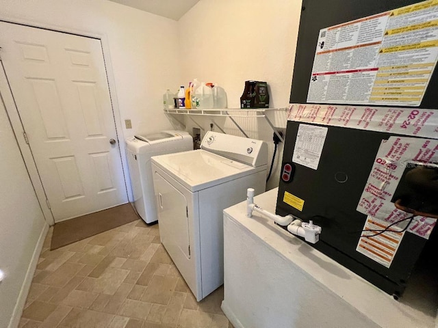 clothes washing area with independent washer and dryer and baseboards