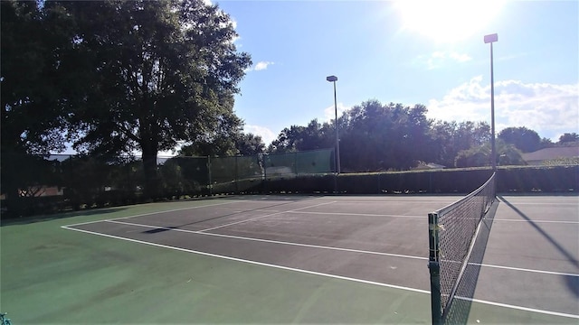 view of tennis court with fence and community basketball court