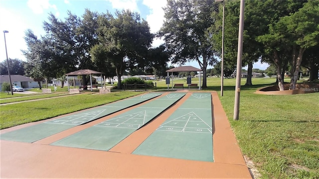 view of property's community featuring a gazebo, a yard, and shuffleboard