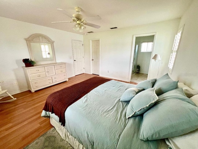 bedroom featuring wood finished floors, baseboards, and ceiling fan
