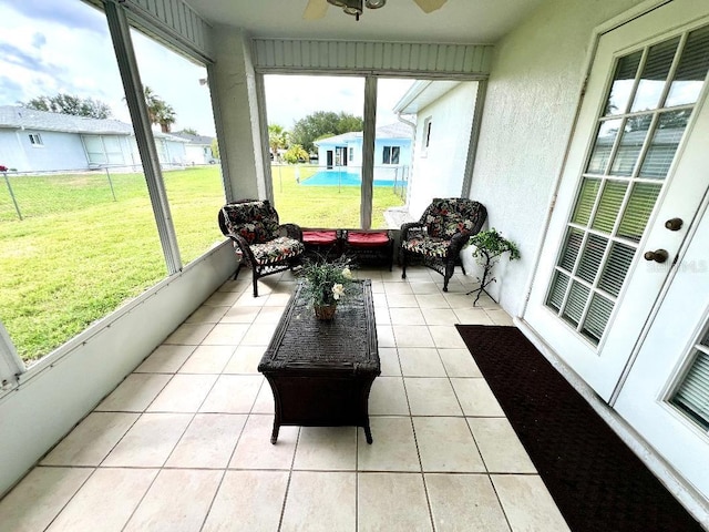 sunroom / solarium with ceiling fan and an outdoor living space