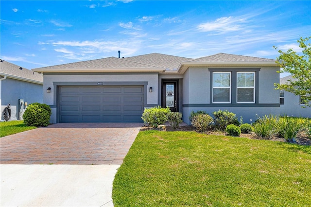 ranch-style house featuring a garage, decorative driveway, a front lawn, and stucco siding
