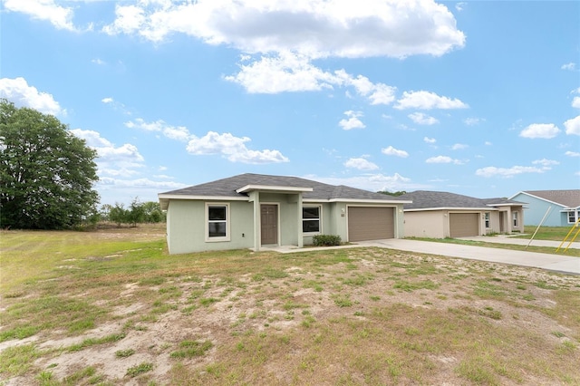 69 Juniper Trail Loop, Ocala, FL 34480 - view of front facade with concrete driveway, a front yard, stucco siding, and an attached garage