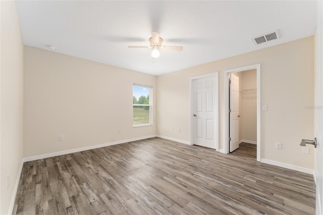 69 Juniper Trail Loop, Ocala, FL 34480 - unfurnished bedroom with baseboards, a walk in closet, visible vents, and wood finished floors