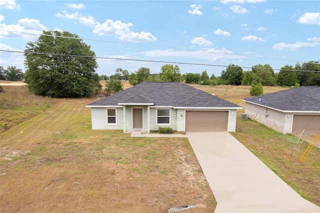 69 Juniper Trail Loop, Ocala, FL 34480 - view of front of house with driveway, an attached garage, stucco siding, a front yard, and roof with shingles