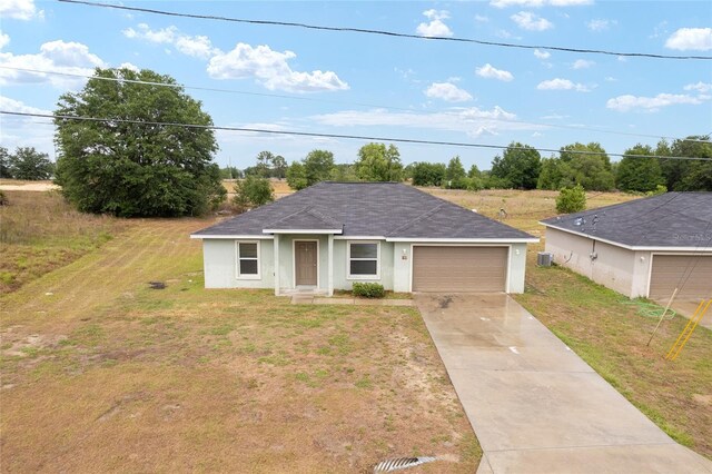 69 Juniper Trail Loop, Ocala, FL 34480 - view of front of home featuring an attached garage, stucco siding, concrete driveway, a shingled roof, and a front yard