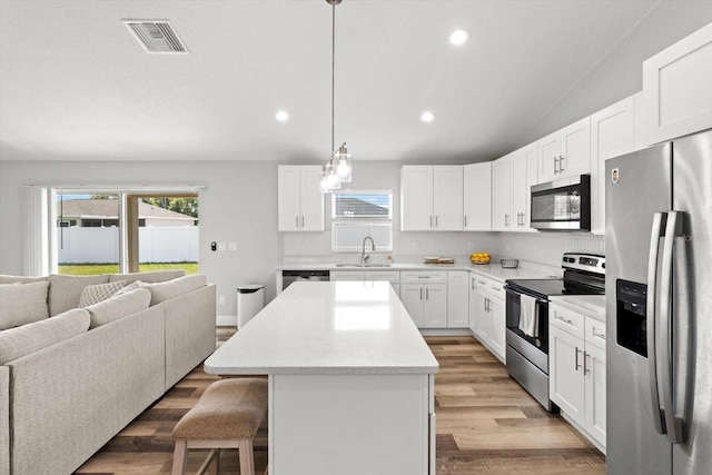 9 Walnut Run, Ocala, FL 34480 - kitchen featuring visible vents, a sink, open floor plan, a kitchen island, and appliances with stainless steel finishes