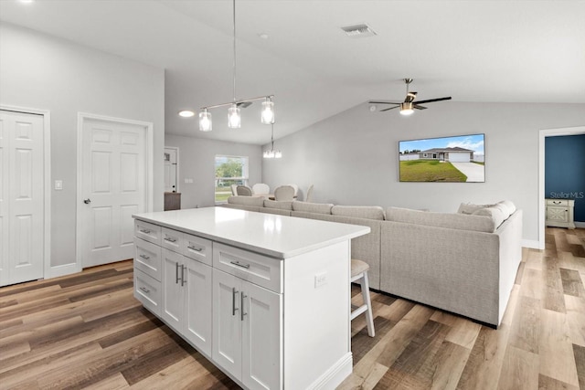 9 Walnut Run, Ocala, FL 34480 - kitchen featuring a kitchen island, white cabinets, ceiling fan, light wood-style floors, and vaulted ceiling