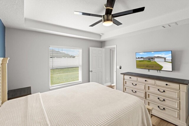 9 Walnut Run, Ocala, FL 34480 - bedroom with a ceiling fan, a textured ceiling, visible vents, a raised ceiling, and light wood-style floors
