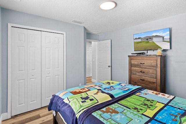 9 Walnut Run, Ocala, FL 34480 - bedroom featuring a closet, light wood finished floors, visible vents, and a textured ceiling