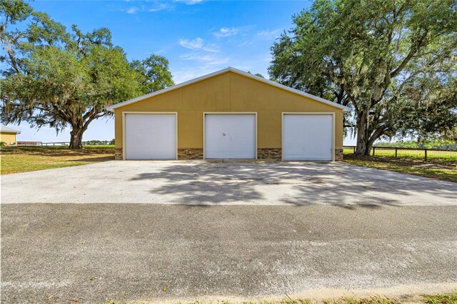 detached garage featuring fence