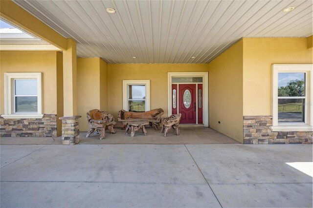 doorway to property with stone siding and stucco siding