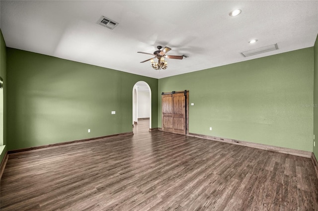 spare room with visible vents, arched walkways, and wood finished floors