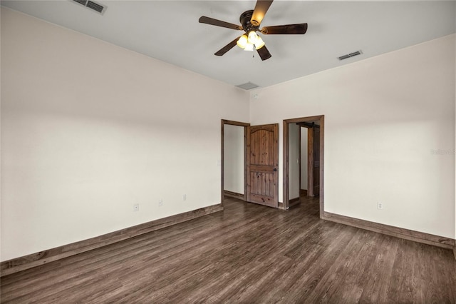 empty room featuring visible vents, a ceiling fan, dark wood-style flooring, and baseboards