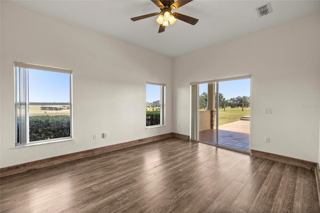 unfurnished room with baseboards, ceiling fan, visible vents, and wood finished floors