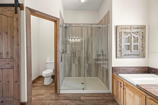 full bathroom featuring vanity, a shower stall, toilet, and wood finished floors