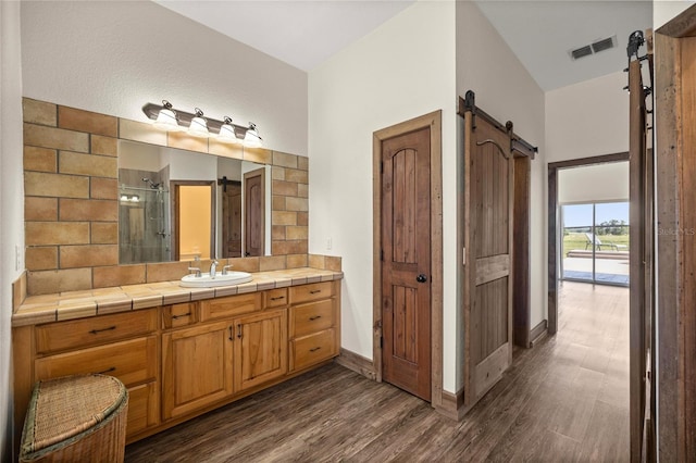 full bathroom with visible vents, a stall shower, wood finished floors, vanity, and baseboards