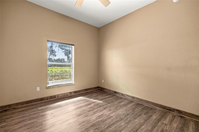 spare room featuring baseboards, a ceiling fan, and wood finished floors