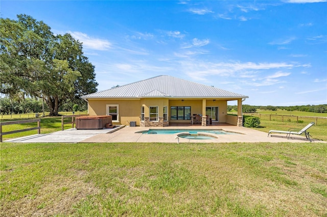 rear view of house with a hot tub, fence, a patio area, and stucco siding