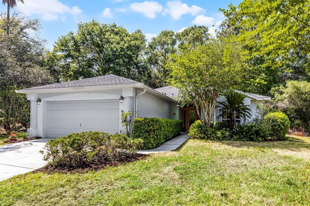 view of front of property featuring stucco siding, a garage, a front yard, and concrete driveway