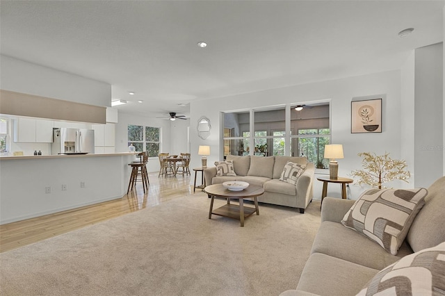 living room with ceiling fan, light wood-style floors, and recessed lighting