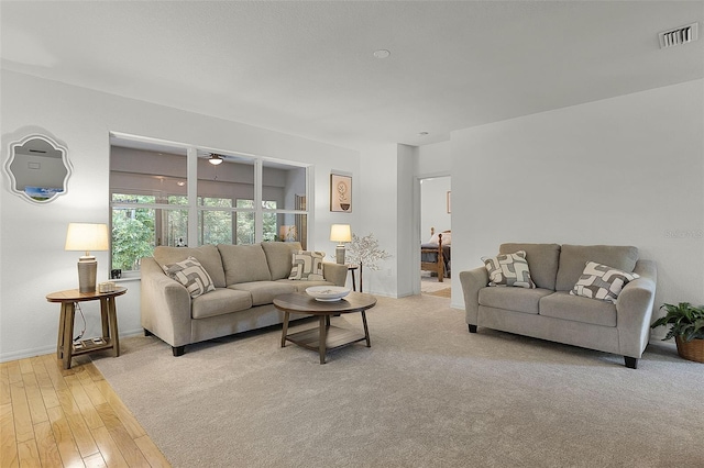 living area with ceiling fan, light wood-style floors, and baseboards