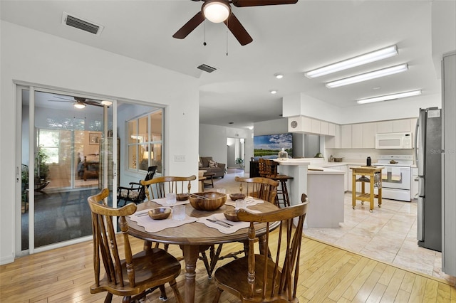 dining area with ceiling fan and light wood-style flooring