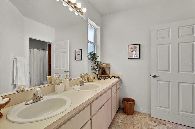 full bath featuring double vanity, baseboards, and a shower with curtain
