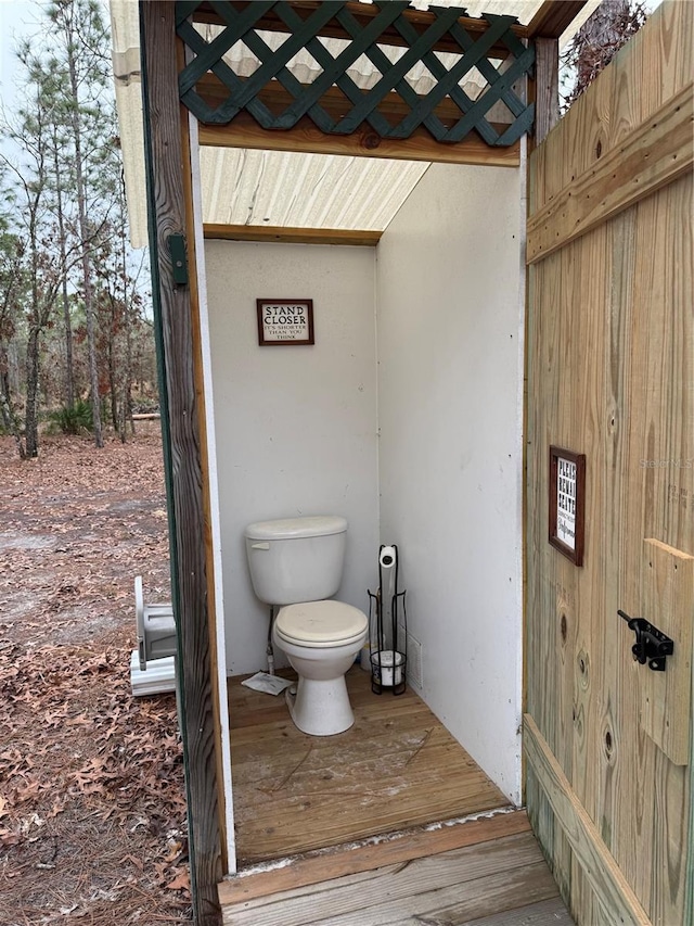 bathroom with toilet and hardwood / wood-style flooring
