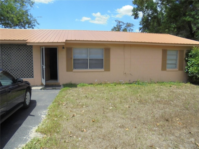 2912 NE 24th Ct, Ocala, FL 34479 - single story home featuring stucco siding, a front lawn, and metal roof
