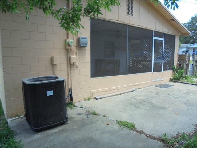 2912 NE 24th Ct, Ocala, FL 34479 - exterior space featuring central air condition unit, a patio, concrete block siding, and a sunroom