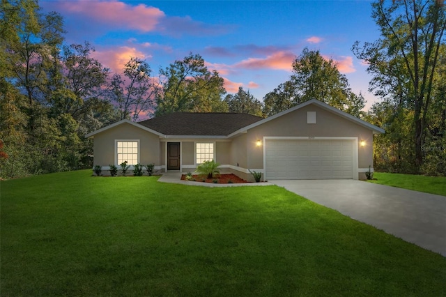 single story home featuring a yard, an attached garage, concrete driveway, and stucco siding