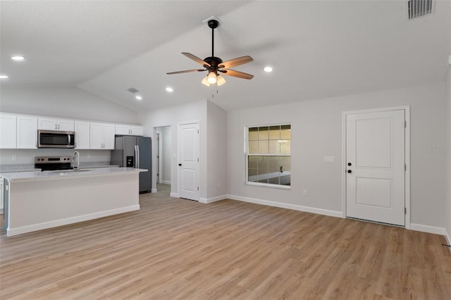kitchen with visible vents, appliances with stainless steel finishes, light wood-type flooring, a sink, and lofted ceiling