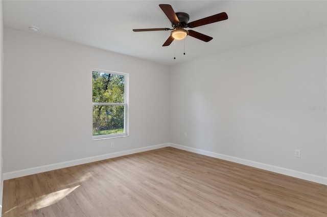 spare room with light wood-type flooring, baseboards, and ceiling fan