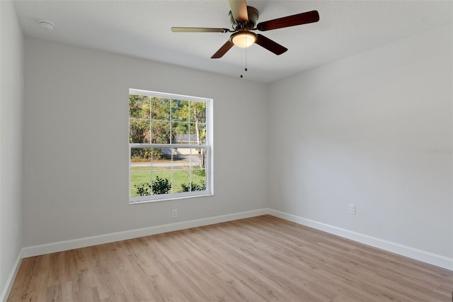 spare room with baseboards, ceiling fan, and light wood-style floors