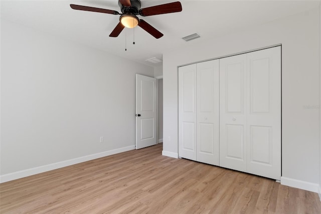 unfurnished bedroom featuring visible vents, light wood-style floors, baseboards, and a closet
