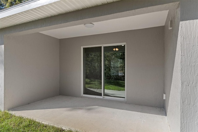 doorway to property with a patio area and stucco siding
