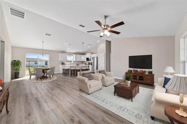living room with lofted ceiling, light wood-type flooring, a ceiling fan, and recessed lighting