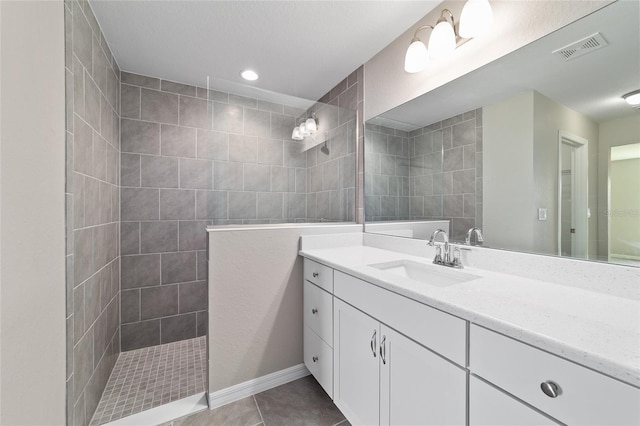full bath with vanity, walk in shower, and tile patterned floors