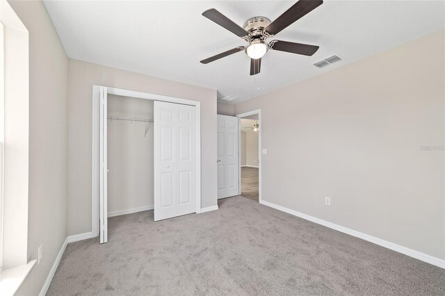 unfurnished bedroom featuring carpet, baseboards, and a closet