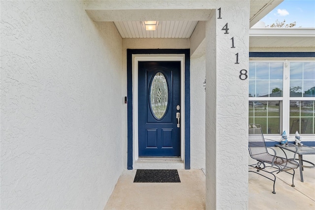 property entrance with stucco siding