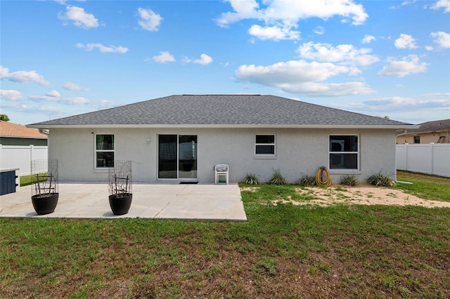 back of house with fence, stucco siding, and a lawn