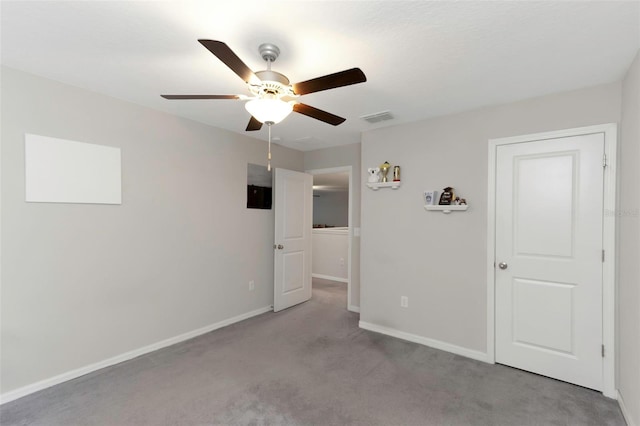 unfurnished bedroom featuring carpet flooring, a ceiling fan, baseboards, and visible vents