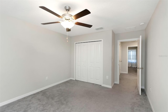 unfurnished bedroom with baseboards, visible vents, light carpet, and a closet