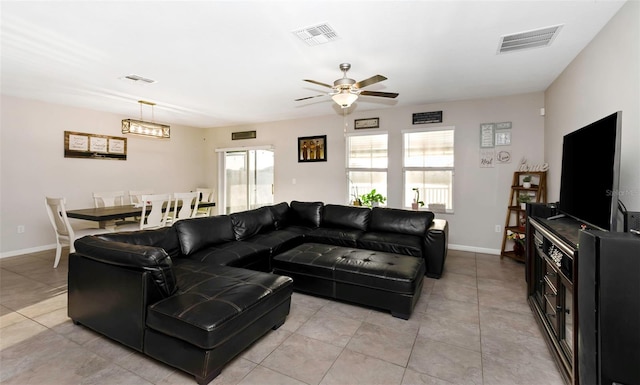 living area with ceiling fan, visible vents, and baseboards
