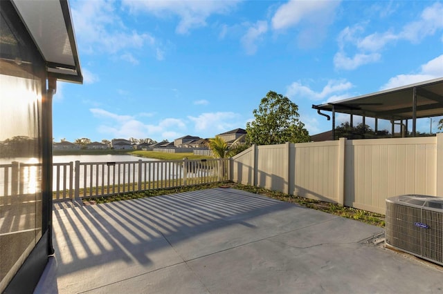 view of patio with a fenced backyard, a residential view, a water view, and cooling unit