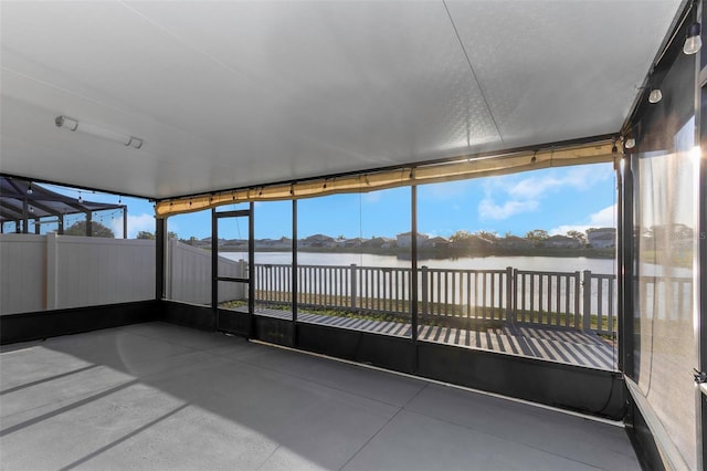 unfurnished sunroom with a water view