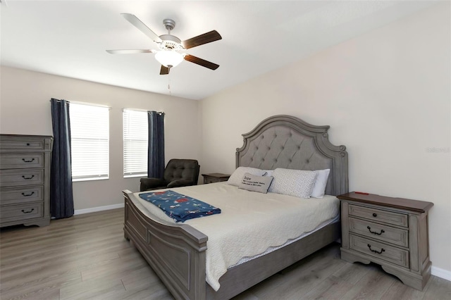 bedroom with a ceiling fan, baseboards, and light wood-style floors